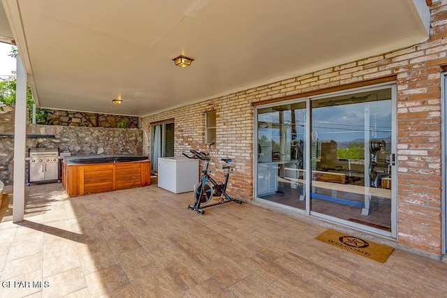 view of patio / terrace with area for grilling and a hot tub