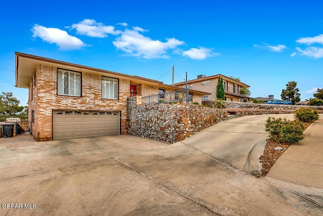 view of front of property with an attached garage, brick siding, and driveway