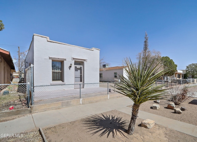 view of front of house with a fenced front yard and stucco siding