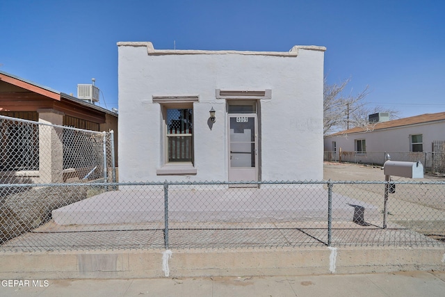 view of front of property featuring central air condition unit, fence, and stucco siding