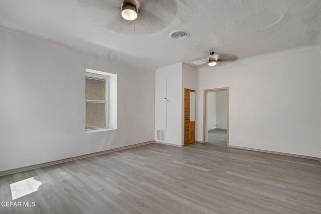 spare room featuring visible vents, ceiling fan, a textured ceiling, and wood finished floors