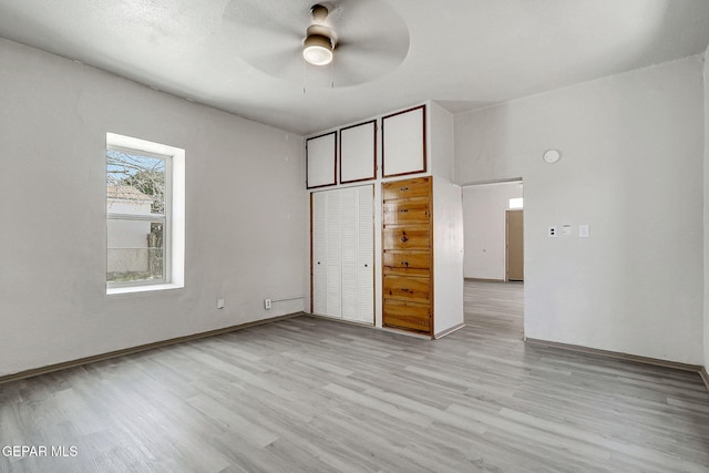 unfurnished bedroom featuring ceiling fan, light wood finished floors, and a closet