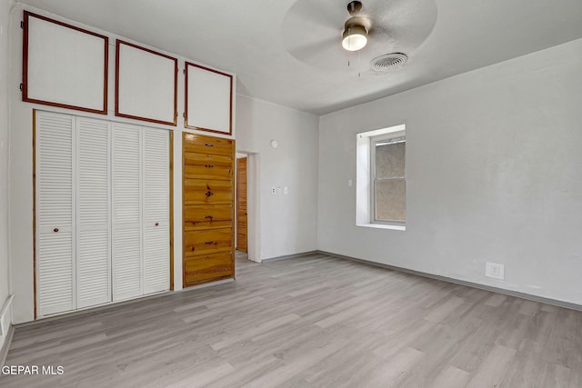 unfurnished bedroom featuring light wood-type flooring, ceiling fan, visible vents, and a closet