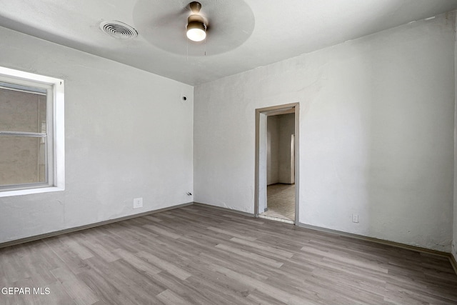 unfurnished room featuring visible vents and wood finished floors