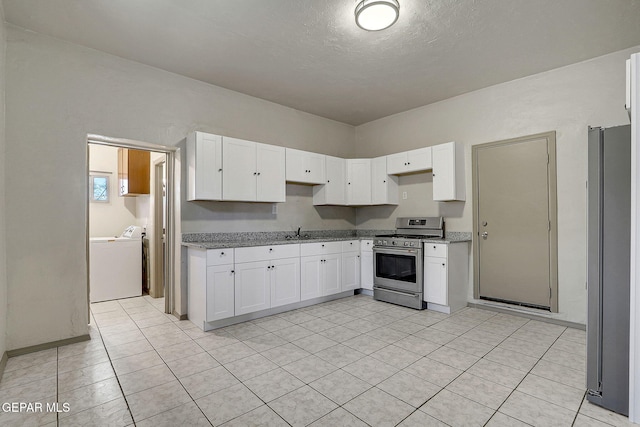 kitchen featuring appliances with stainless steel finishes, washer / dryer, white cabinets, and light stone counters