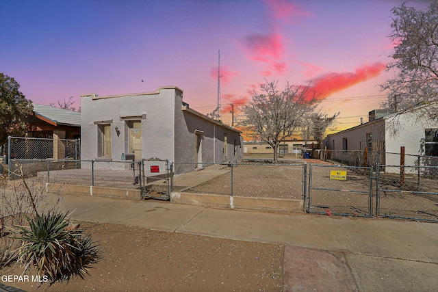 view of front of property featuring a fenced front yard, a gate, and stucco siding