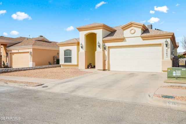 mediterranean / spanish home featuring a garage, driveway, and stucco siding