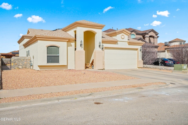 mediterranean / spanish-style house featuring a garage, fence, concrete driveway, and stucco siding