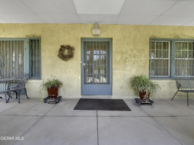 property entrance featuring a patio and stucco siding