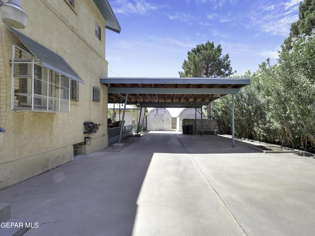 view of car parking with concrete driveway and an attached carport