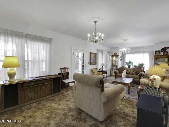 living room with dark carpet and an inviting chandelier