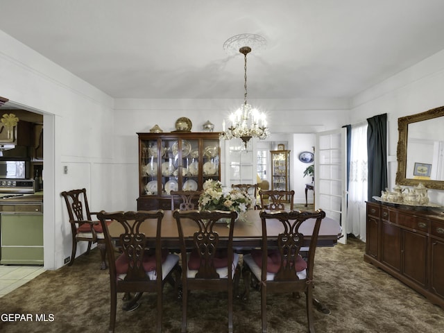 carpeted dining area with a chandelier and a decorative wall