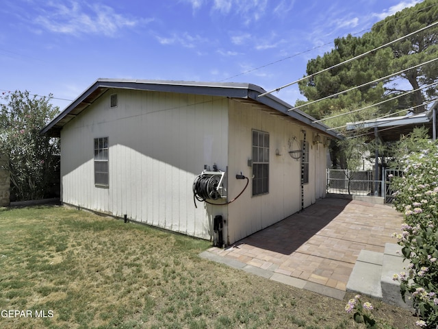 view of property exterior featuring a lawn and a patio