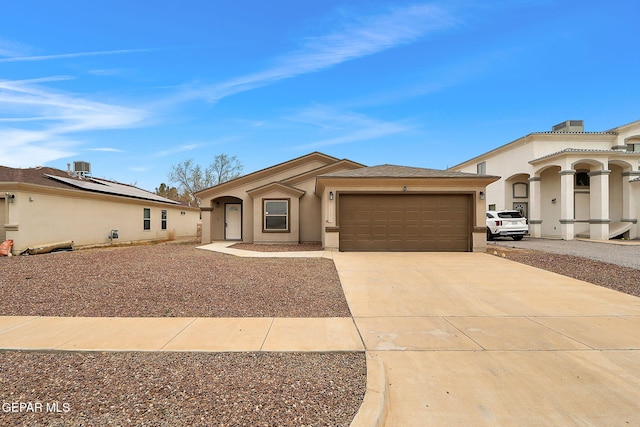 view of front of property with a garage, concrete driveway, and stucco siding