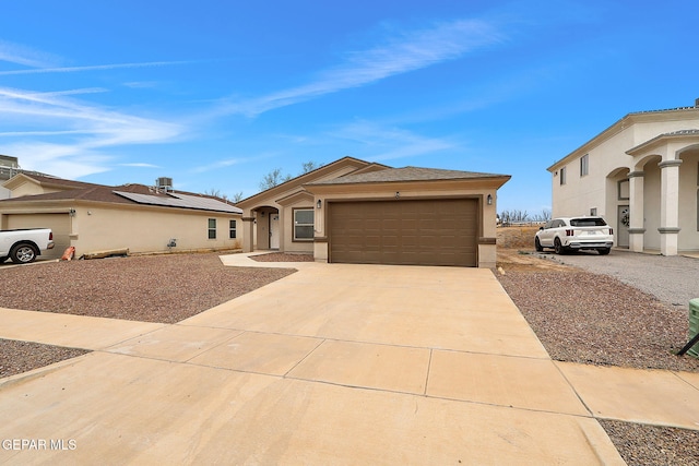 view of front of property featuring driveway, an attached garage, and stucco siding