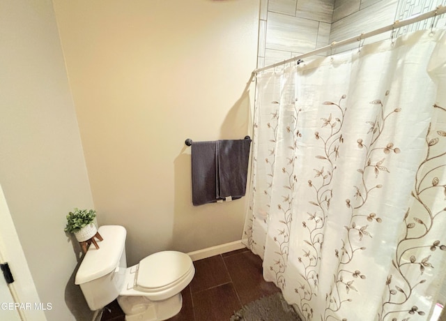 full bathroom with toilet, curtained shower, wood tiled floor, and baseboards