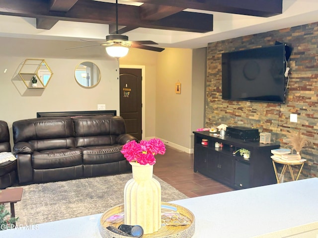 living room featuring a ceiling fan, beamed ceiling, and baseboards