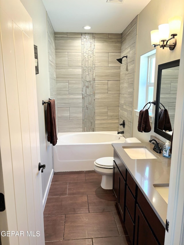 full bathroom with double vanity, visible vents, bathing tub / shower combination, toilet, and a sink