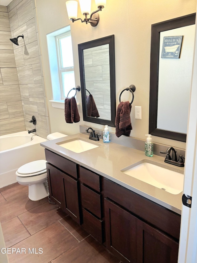 full bathroom with tub / shower combination, a sink, toilet, and double vanity