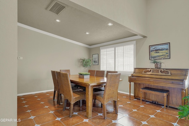 dining room with baseboards, tile patterned flooring, visible vents, and crown molding