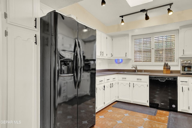 kitchen with black appliances, light tile patterned flooring, a sink, and white cabinetry