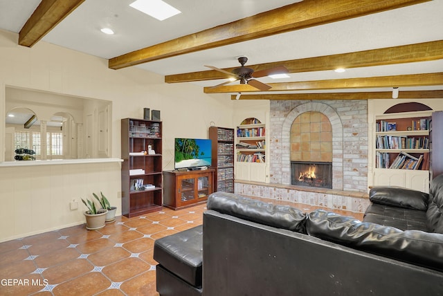 tiled living area featuring built in features, a fireplace, ceiling fan, beamed ceiling, and baseboards