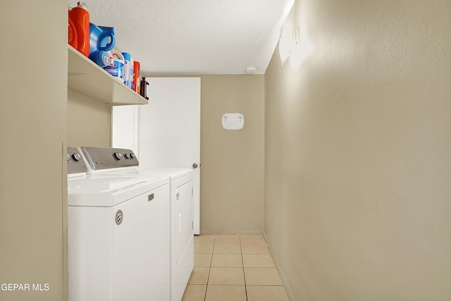 laundry room with light tile patterned floors, a textured ceiling, laundry area, separate washer and dryer, and baseboards