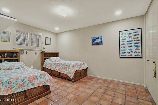 bedroom featuring a textured ceiling and baseboards