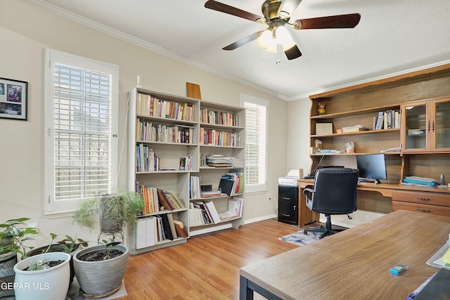 home office with ornamental molding, light wood-type flooring, baseboards, and a ceiling fan