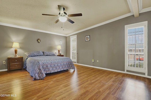 bedroom featuring crown molding, a textured ceiling, baseboards, and wood finished floors