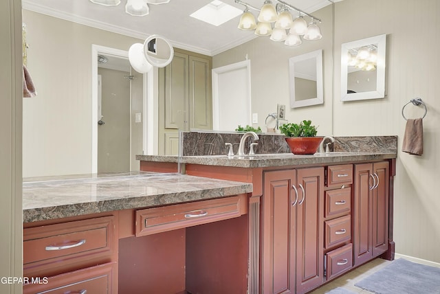 bathroom featuring double vanity, a skylight, a sink, and crown molding