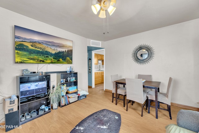 dining area featuring wood finished floors, visible vents, and baseboards