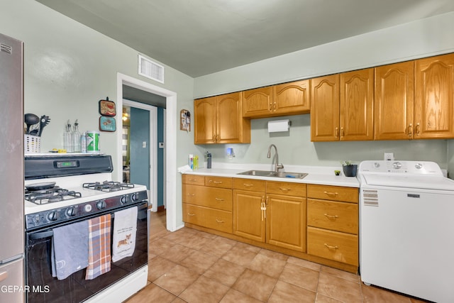 kitchen with washer / dryer, visible vents, light countertops, a sink, and gas stove