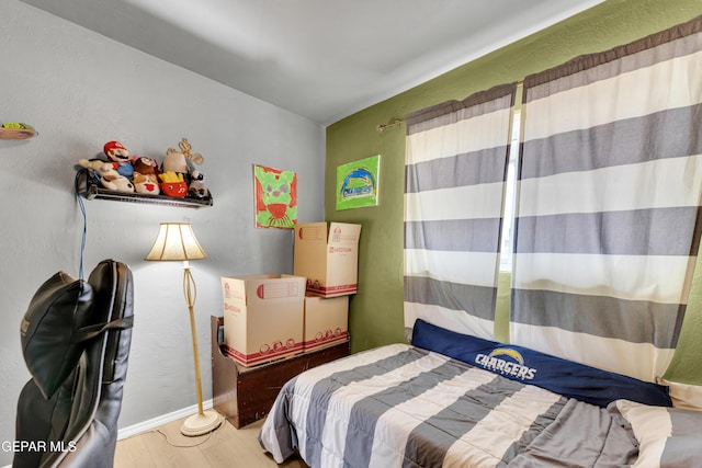 bedroom with baseboards and wood finished floors