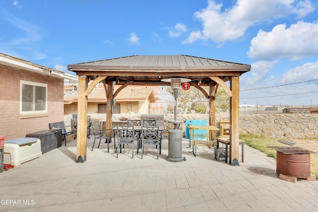 view of patio featuring a gazebo, outdoor dining area, and fence