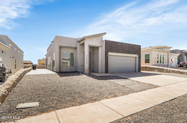 view of front facade featuring concrete driveway, an attached garage, and stucco siding