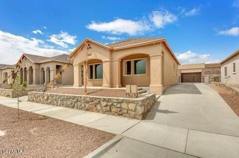 mediterranean / spanish home with a garage, fence, and stucco siding