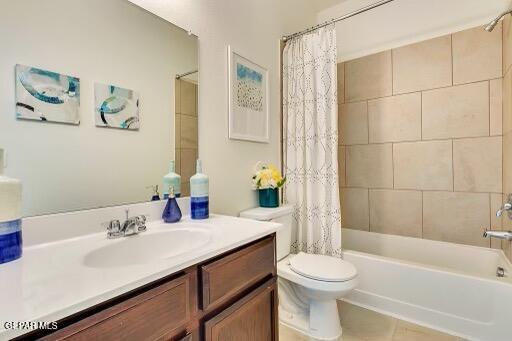 bathroom featuring toilet, shower / bath combination with curtain, and vanity