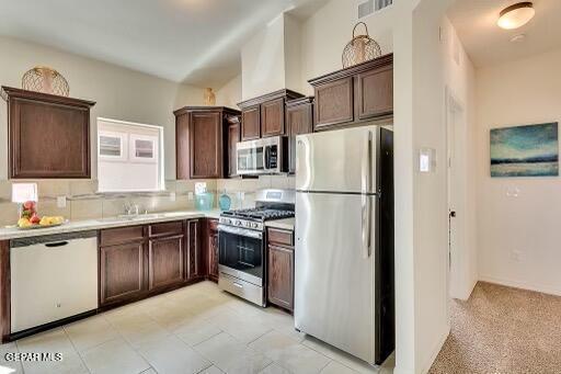 kitchen with stainless steel appliances, visible vents, a sink, and dark brown cabinets