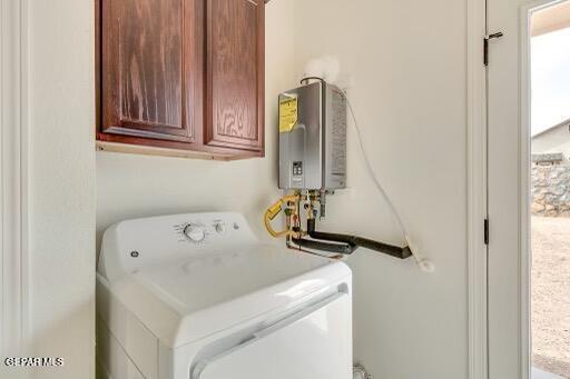 clothes washing area featuring cabinet space and water heater