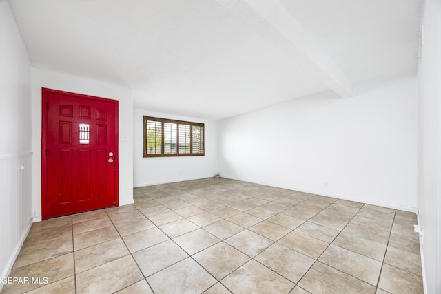 entrance foyer featuring light tile patterned floors and beamed ceiling