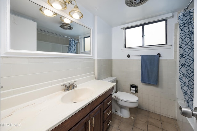 full bath with tile walls, toilet, wainscoting, vanity, and tile patterned flooring