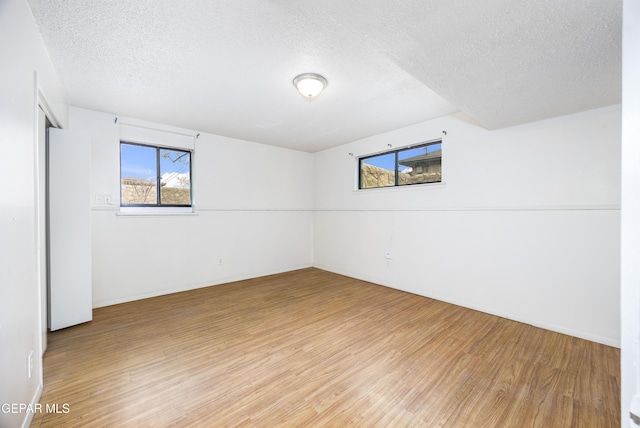 empty room featuring light wood-style floors and a textured ceiling