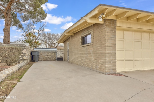 view of side of home featuring a garage and brick siding