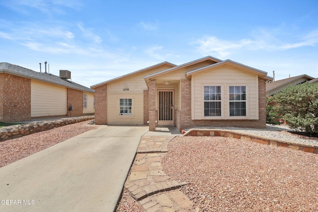 view of front facade with a patio area, brick siding, and central air condition unit