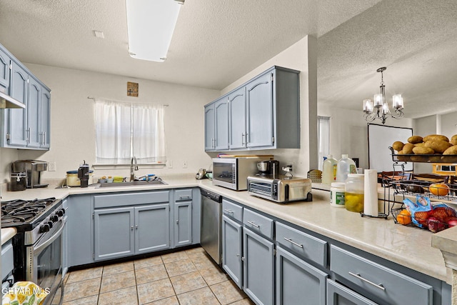 kitchen featuring stainless steel appliances, a sink, light countertops, and a toaster