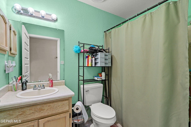 bathroom with a textured wall, vanity, toilet, and a shower with curtain