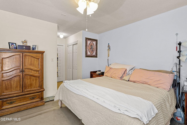 bedroom with light wood-style flooring, a textured ceiling, ceiling fan, and a closet