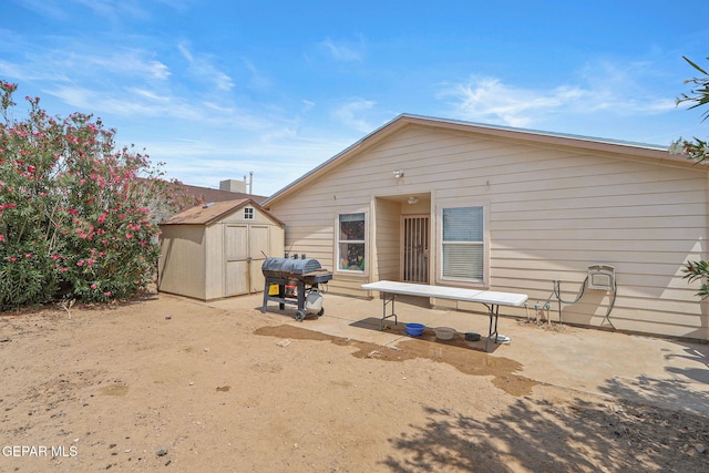 back of property featuring a storage shed, a patio area, and an outdoor structure