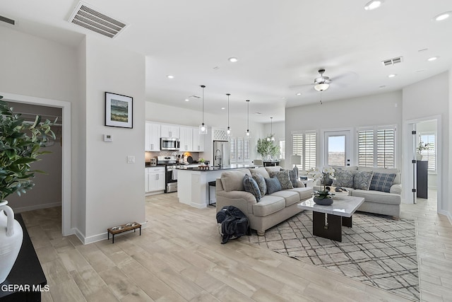 living area featuring recessed lighting, visible vents, and light wood-style floors